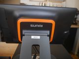 an orange and black computer monitor sitting on top of a desk