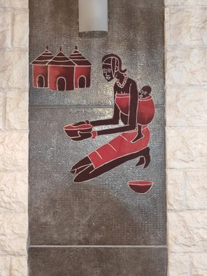 une peinture sur le mur d'un immeuble représentant une femme tenant un bol