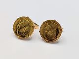 a close up of a pair of gold cufflinks with a cat on it