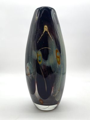 un vase noir orné d'un motif sur fond blanc