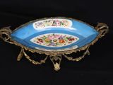 a blue bowl with flowers on it sitting on a black surface
