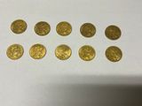 a bunch of gold coins sitting on top of a white table