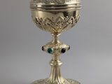 un calice en argent richement décoré, surmonté d'une croix