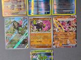 Plusieurs cartes Pokémon différentes sont posées sur une table dans une pièce.