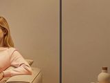 a woman sitting on a couch in a living room next to a lamp