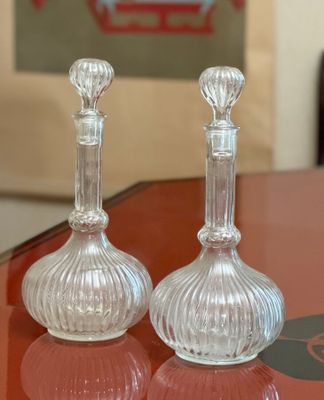 pair of clear glass candlesticks sitting on top of a red table