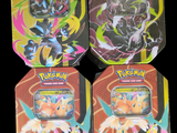 trois boîtes à Pokémon ornées de motifs différents sur fond noir