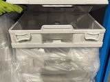 a stack of plastic containers on a cart in a store