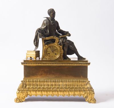 une statue d'un homme assis au sommet d'une horloge