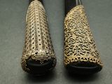two pairs of black and gold canes on a table