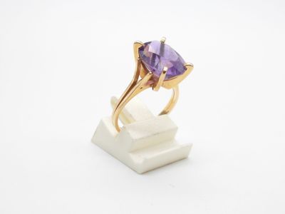 gros plan d'une bague en or avec une pierre en améthorate