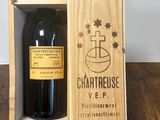 La bouteille de vin se trouve dans une caisse en bois posée sur la table.