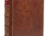 un livre ancien avec une couverture en cuir marron et des bordures dorées