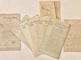 many old papers on a table with a pen and ink