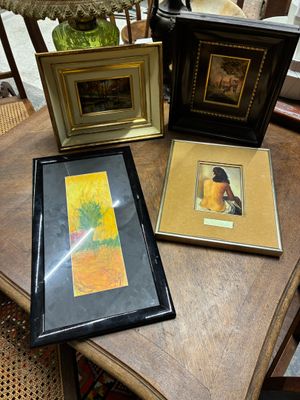 trois photos encadrées posées sur une table, à côté d'une lampe