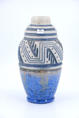 un vase bleu et blanc posé sur une surface blanche