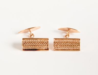 une paire de boutons de manchette en or sur fond blanc