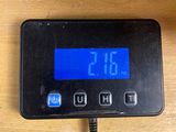a digital clock that is on the wall next to a charger