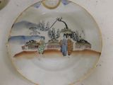 a plate with a painting on it sitting on a table