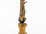 an image of a statue of a woman standing on top of a ball