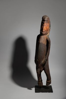 an old wooden statue of a man with a helmet on his head