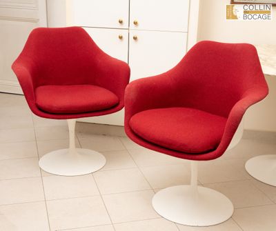 deux chaises rouges dans une pièce où se trouve une table blanche