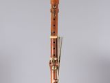 a close up of a wooden clarinet on a clear stand