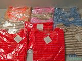 de nombreux t-shirts de différentes couleurs exposés dans une boîte