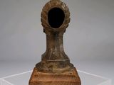 a small vase with a black hole in it