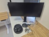 a computer desk with a monitor, speakers, and headphones