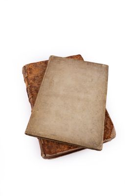 three old books stacked on top of each other on a white surface