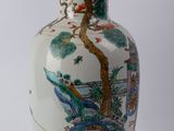 a white vase with a painting on it sitting on a table