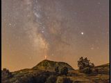 La Voie lactée brille de mille feux dans le ciel, au-dessus d'une colline verdoyante.