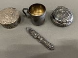 a silver cup, a spoon, and a spoon rest on a table