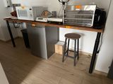 une petite cuisine équipée d'un micro-ondes, d'un réfrigérateur et d'un tabouret de bar