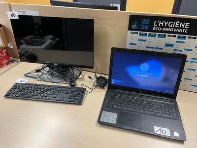 un ordinateur portable posé sur un bureau, à côté d'un écran et d'un clavier