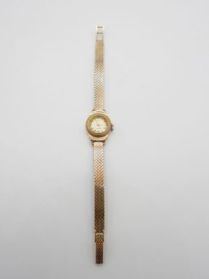 l'image d'une montre en or sur une surface blanche