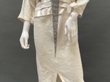 an image of a mannequin wearing a beige dress and jacket