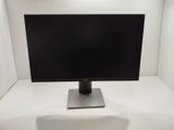 a computer monitor sitting on a stand in a white room