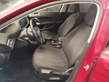 the interior of a red car with a steering wheel and seat covers