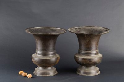 deux vases en métal posés l'un à côté de l'autre sur une table