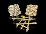 deux paires de boucles d'oreilles en or et en argent sur un fond noir