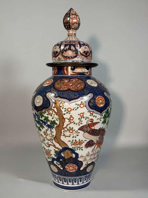 a vase with a lid that has a bird on it