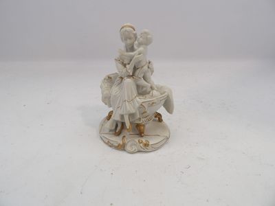 une figurine représentant une femme assise sur un banc