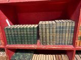 de nombreux livres anciens posés sur une étagère rouge dans une bibliothèque