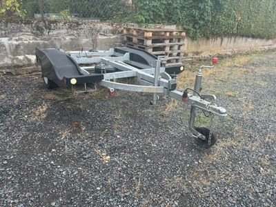 une remorque à laquelle est attelée une autre remorque, sur un terrain en gravier