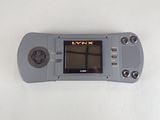 a gray game console with a black screen on a white surface