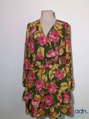 une robe de femme ornée de fleurs roses et jaunes, présentée sur un mannequin
