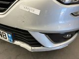 the front of a silver car with a sticker on it ' s bumper