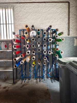 many rolls of yarn on a rack in a room